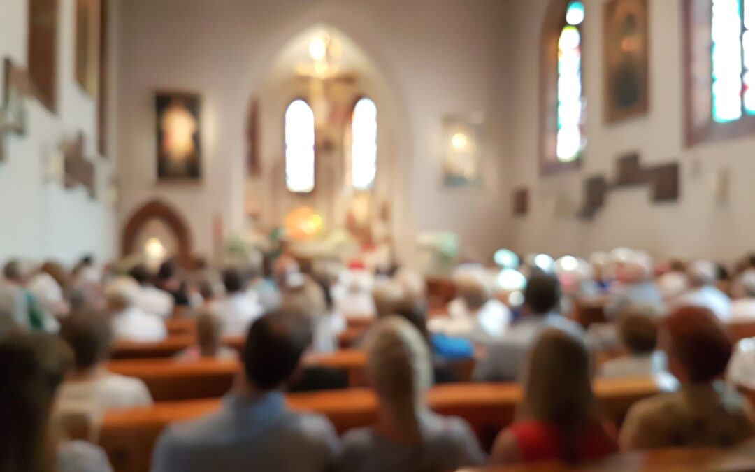 Blurred photo of a congregation gathered inside a church for "Should Churches Have Security" blog.
